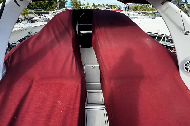 Slide: The Image of 2005 Cobolt 36 boat with red cover, docked among other boats. - 36