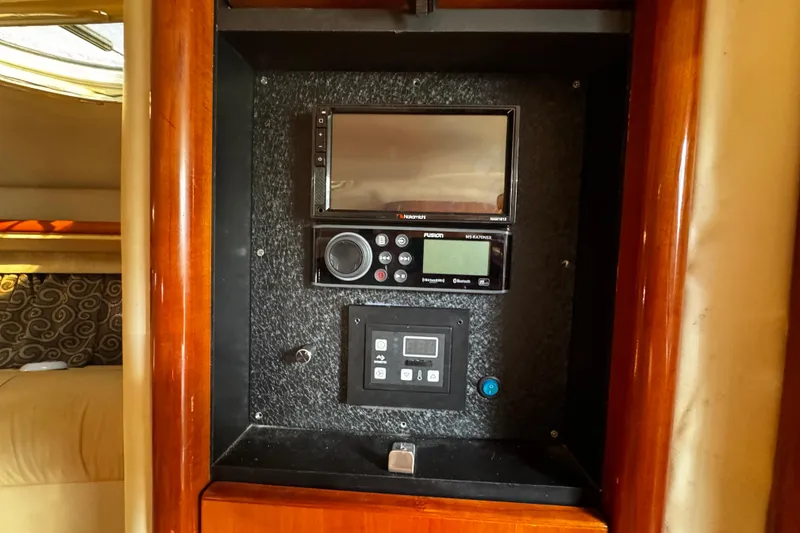 Slide: The Image of Control panel inside a 2005 Cobolt 36 boat, featuring audio and navigation systems. - 19