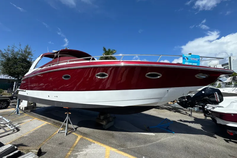The Image of 2005 Cobalt 360 Cruiser boat with red and white hull on display outdoors. - 0