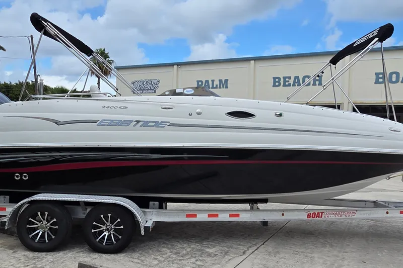 Slide: The Image of 2009 Ebbtide 2400 SS Fun Cruiser O/B on trailer, parked outdoors. - 2