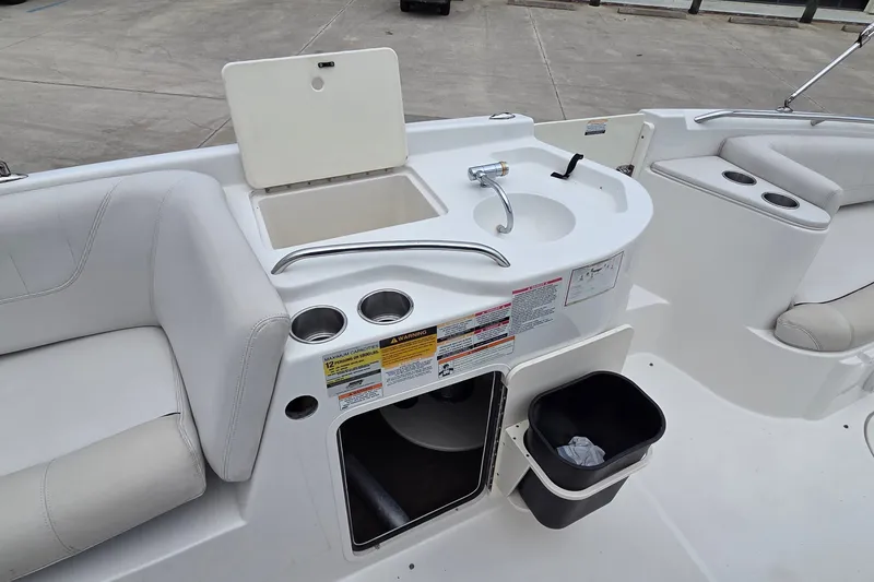Slide: The Image of 2009 Ebbtide 2400 SS Fun Cruiser O/B boat interior with sink and seating area. - 10