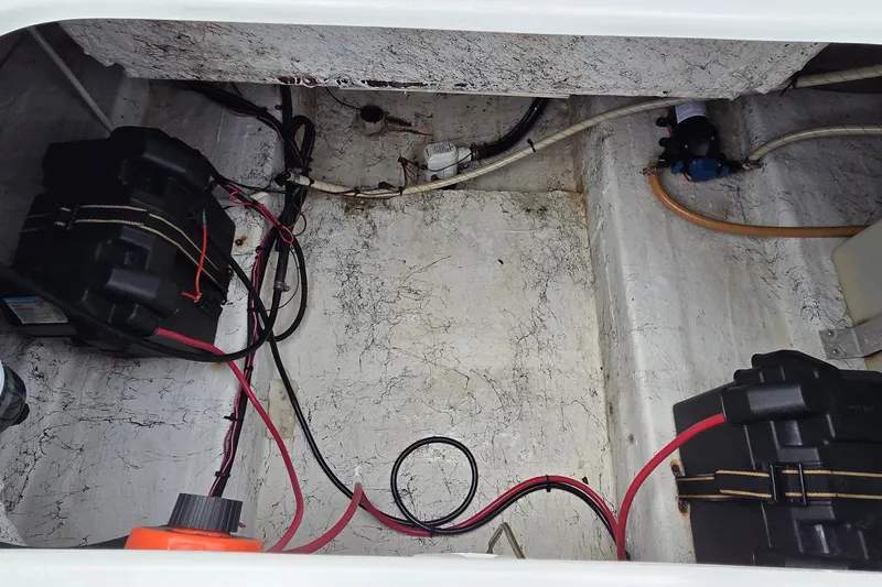 Slide: The Image of 2009 Ebbtide 2400 SS Fun Cruiser O/B battery compartment with wiring and components. - 12