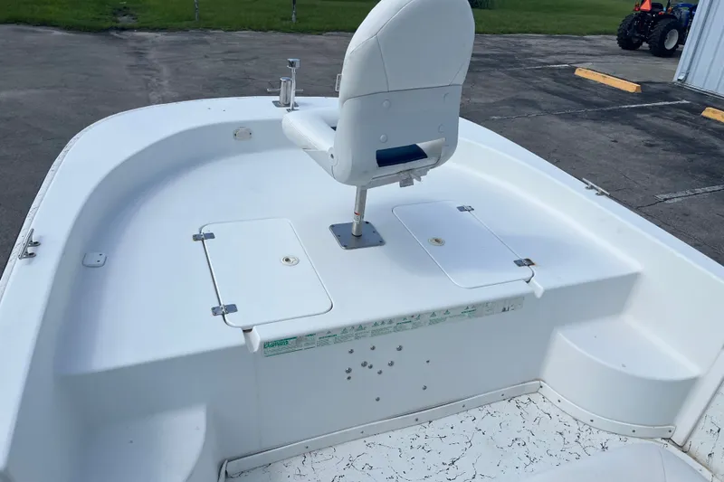 Slide: The Image of 2010 Sea Hunt Skiff 21 boat deck with white seating and storage compartments. - 14