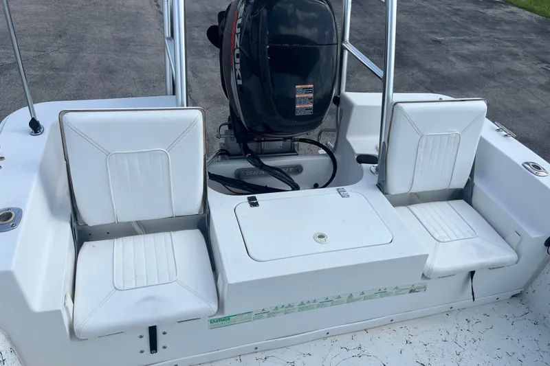 Slide: The Image of 2010 Sea Hunt Skiff 21 boat with Suzuki outboard motor and white seating. - 15