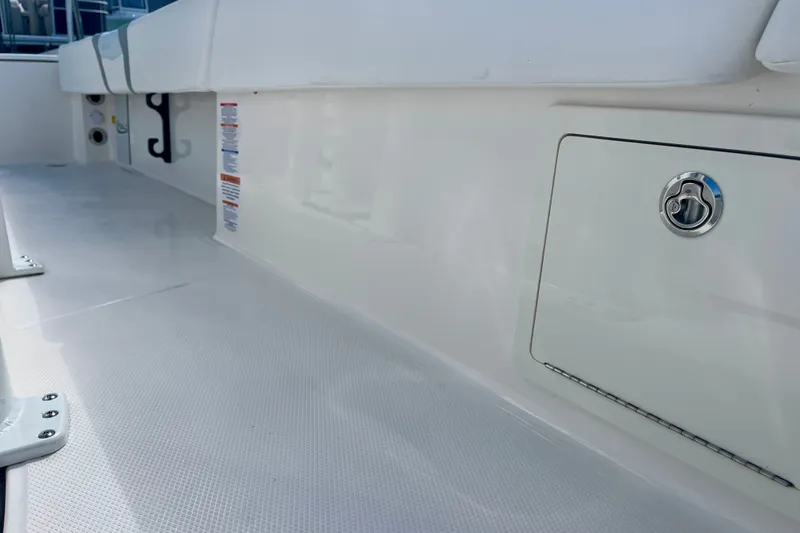 Slide: The Image of 2027 Robalo 266 Cayman boat interior with storage compartment and sleek white finish. - 38