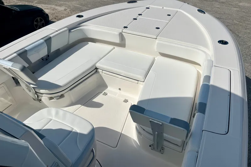 Slide: The Image of 2027 Robalo 266 Cayman boat interior with white cushioned seating and storage compartments. - 30