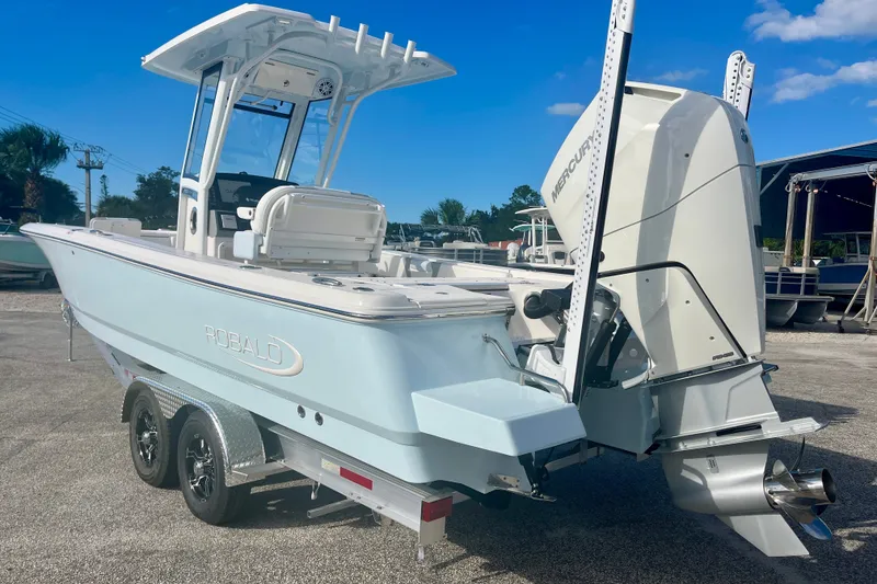 Slide: The Image of 2027 Robalo 266 Cayman boat with Mercury engine on trailer, parked outdoors. - 3
