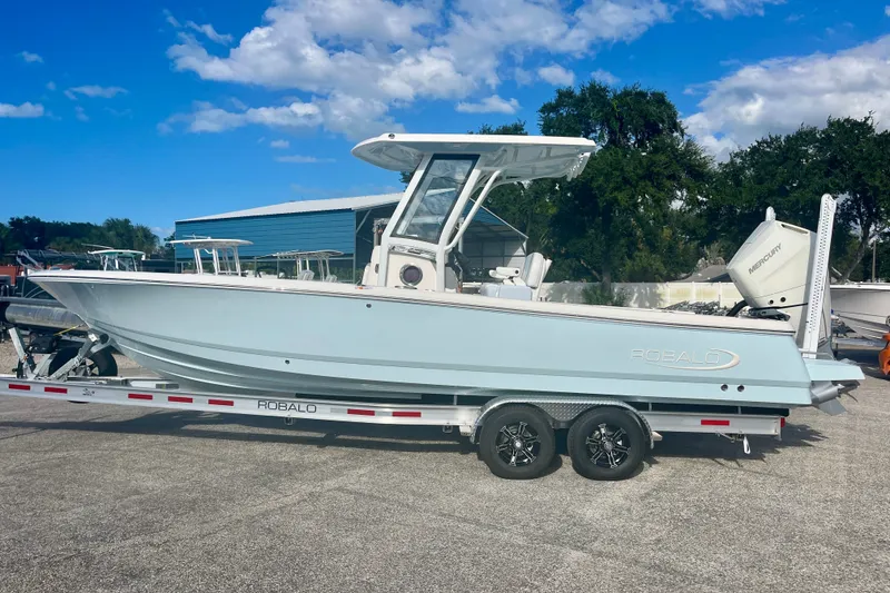 Slide: The Image of 2027 Robalo 266 Cayman boat on trailer under blue sky. - 1
