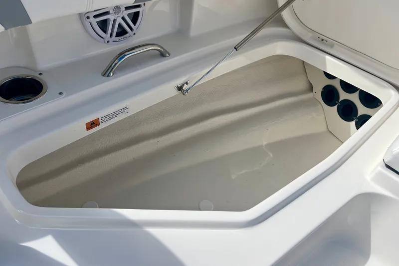 Slide: The Image of Open storage compartment on 2027 Robalo 266 Cayman boat, featuring cup holders and speaker. - 33
