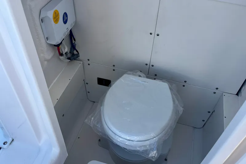 Slide: The Image of 2027 Robalo 266 Cayman boat interior with a compact marine toilet. - 41