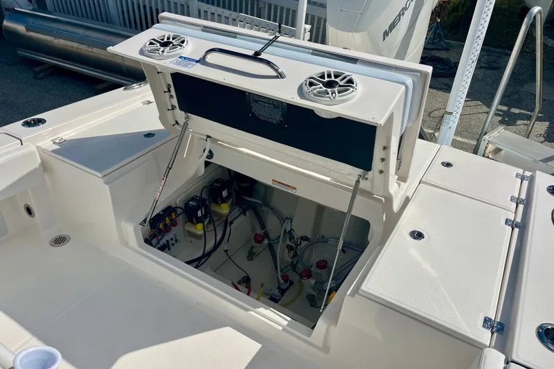 Slide: The Image of 2027 Robalo 266 Cayman boat with open storage compartment and visible wiring. - 15