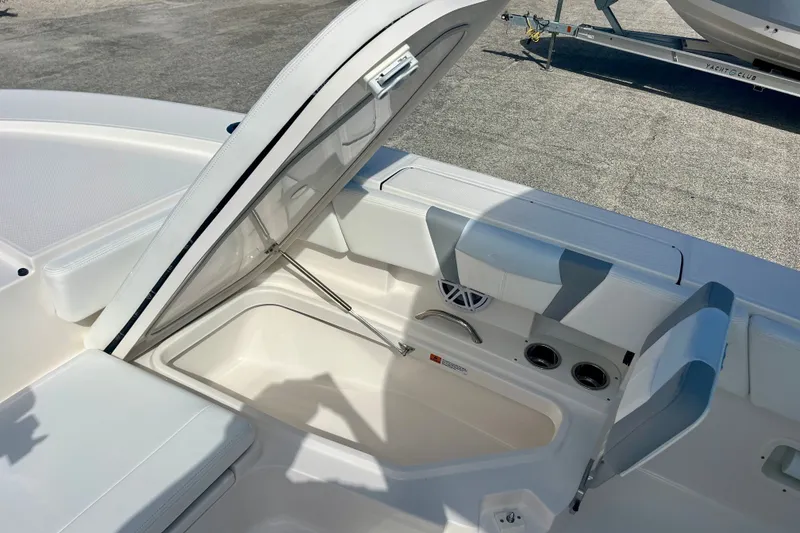Slide: The Image of Open storage compartment on 2027 Robalo 266 Cayman boat, featuring seating and cup holders. - 32
