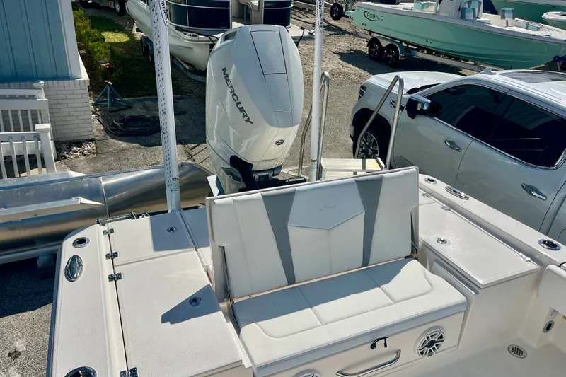 Slide: The Image of 2027 Robalo 266 Cayman boat with Mercury engine, docked near vehicles. - 12