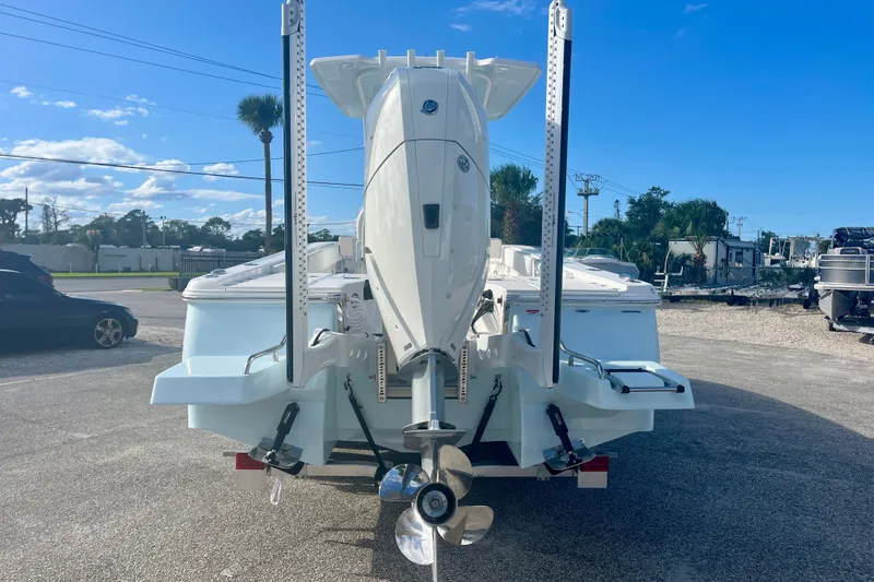 Slide: The Image of 2027 Robalo 266 Cayman boat rear view with outboard motor and blue sky background. - 4