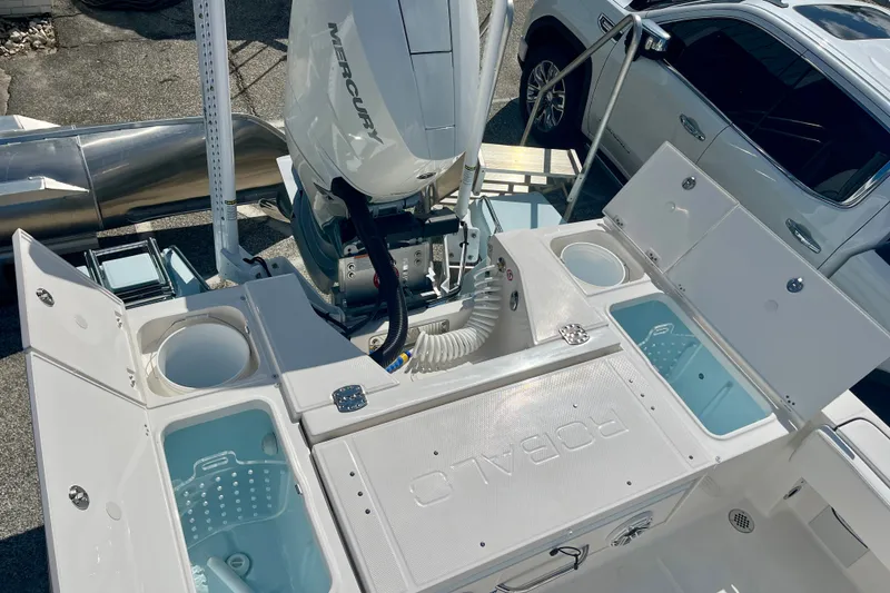 Slide: The Image of 2027 Robalo 266 Cayman boat deck with Mercury engine, featuring storage compartments and live wells. - 13
