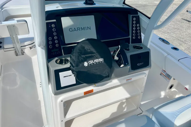 Slide: The Image of 2027 Robalo 266 Cayman boat dashboard with Garmin display and Gussi Italia steering wheel cover. - 24