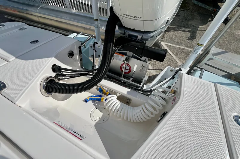 Slide: The Image of 2027 Robalo 266 Cayman boat engine area with Verado motor and coiled hose. - 11