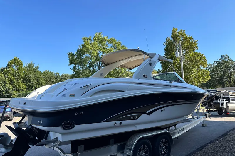 Slide: The Image of 2001 Sea Ray 290 Bowrider on trailer, parked outdoors under clear blue sky. - 2