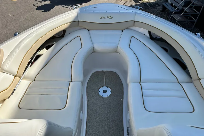Slide: The Image of 2001 Sea Ray 290 Bowrider interior with white cushioned seating and carpeted floor. - 14