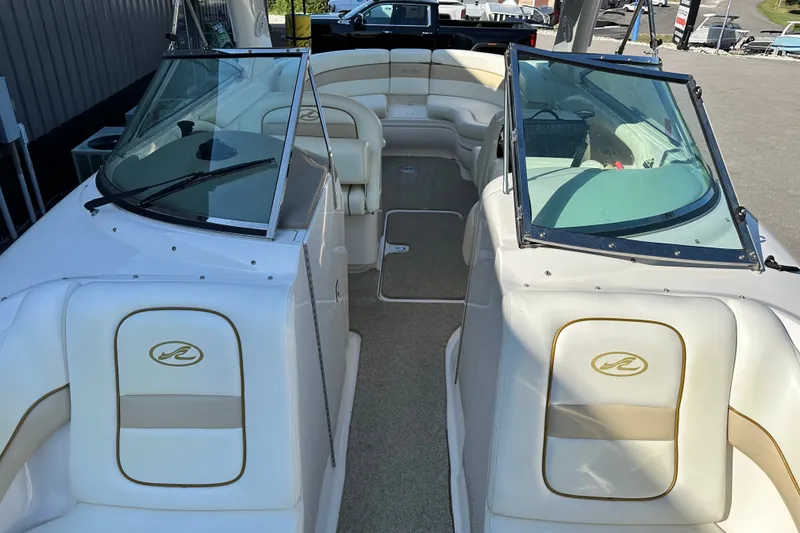 Slide: The Image of 2001 Sea Ray 290 Bowrider interior with white seating and dual windshields. - 15