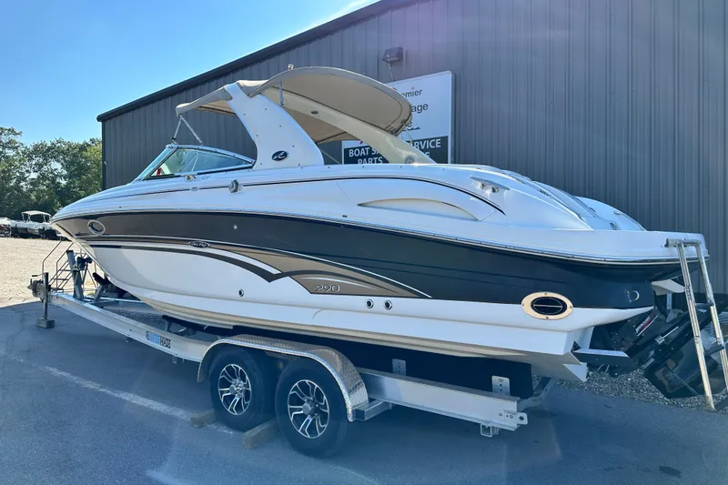 Slide: The Image of 2001 Sea Ray 290 Bowrider boat on trailer, parked outside a building. - 3
