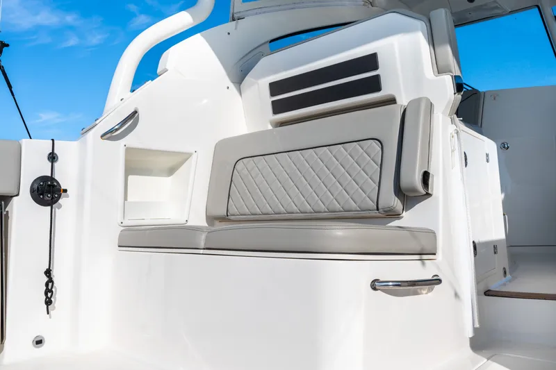 Slide: The Image of 2021 Pursuit DC 365 Dual Console interior with cushioned seating and storage. - 29