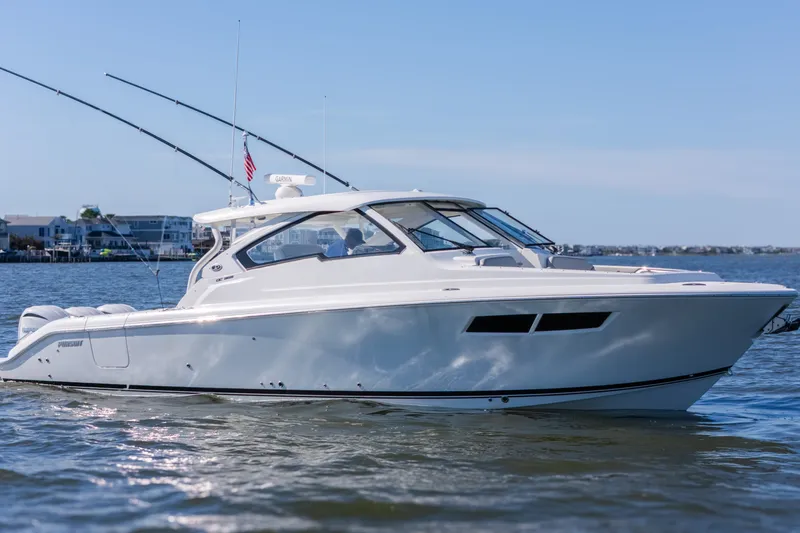 Slide: The Image of 2021 Pursuit DC 365 Dual Console boat on calm water, showcasing sleek design and modern features. - 13
