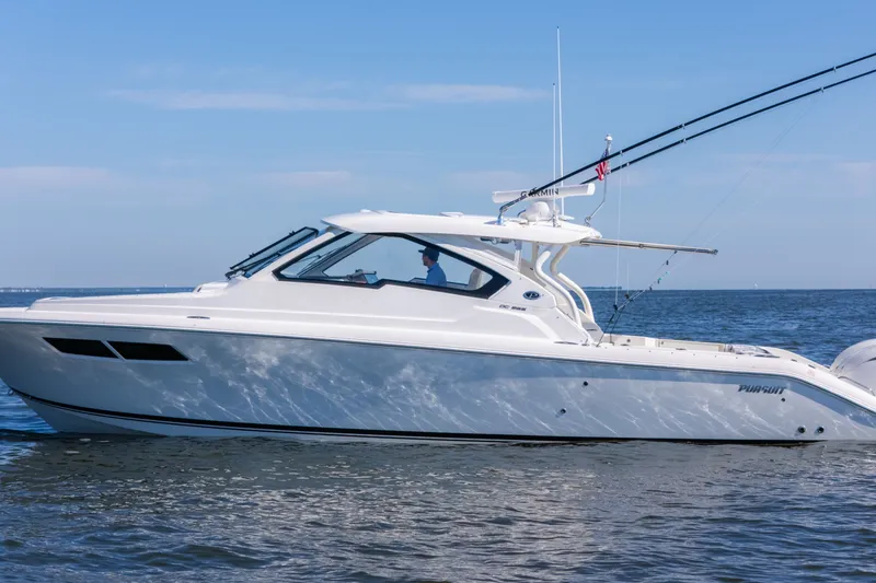 Slide: The Image of 2021 Pursuit DC 365 Dual Console boat cruising on open water. - 19