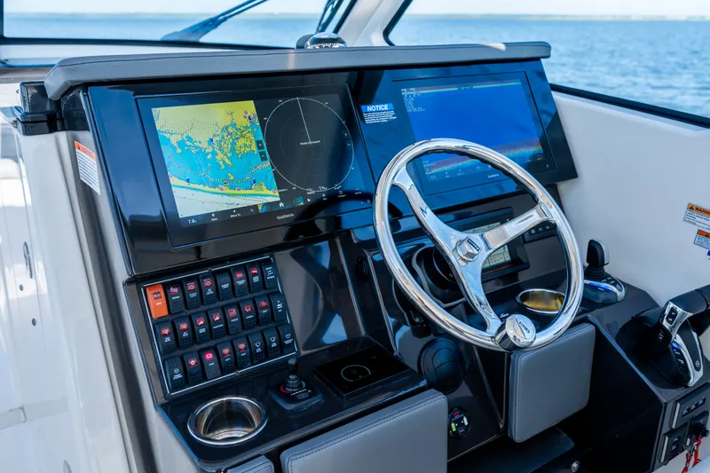Slide: The Image of 2021 Pursuit DC 365 Dual Console helm with navigation screens and steering wheel. - 35