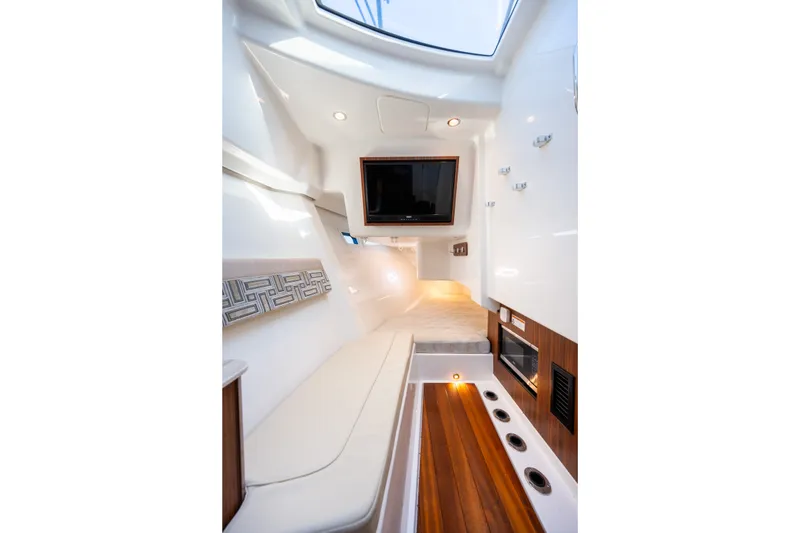 Slide: The Image of Interior of 2021 Pursuit DC 365 Dual Console boat, featuring seating and entertainment system. - 48