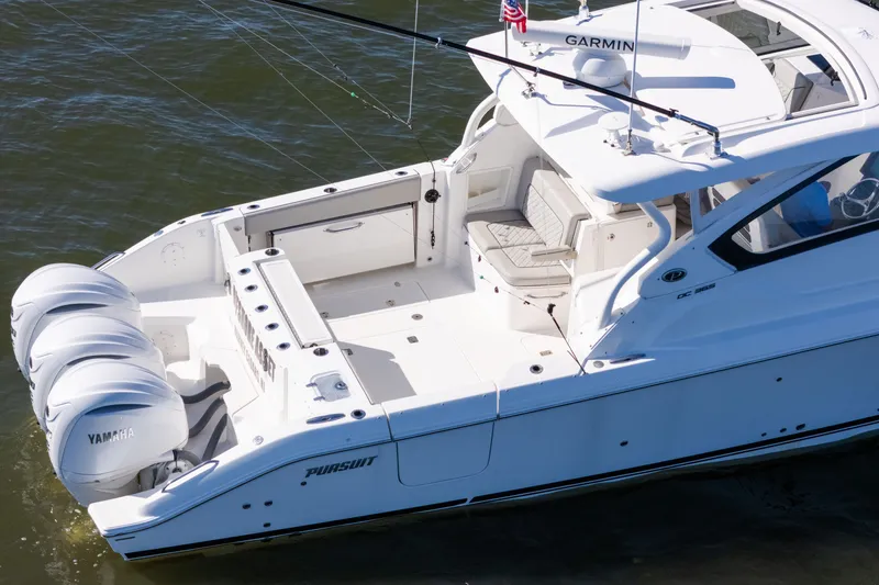 Slide: The Image of 2021 Pursuit DC 365 Dual Console boat with triple Yamaha engines on water. - 17