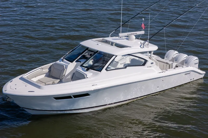 Slide: The Image of 2021 Pursuit DC 365 Dual Console boat on water, featuring sleek design and triple engines. - 16