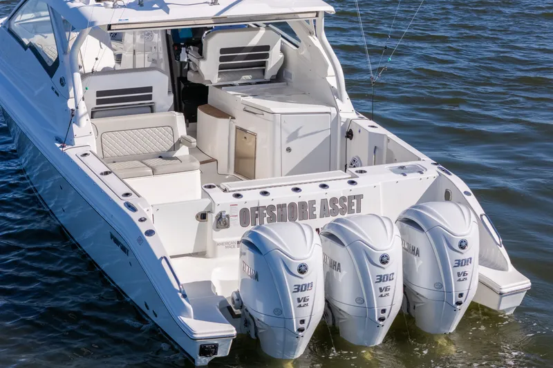 Slide: The Image of 2021 Pursuit DC 365 Dual Console boat with triple Yamaha 300 engines on water. - 9