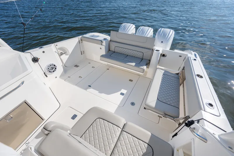 Slide: The Image of 2021 Pursuit DC 365 Dual Console boat interior with seating, on calm water. - 22