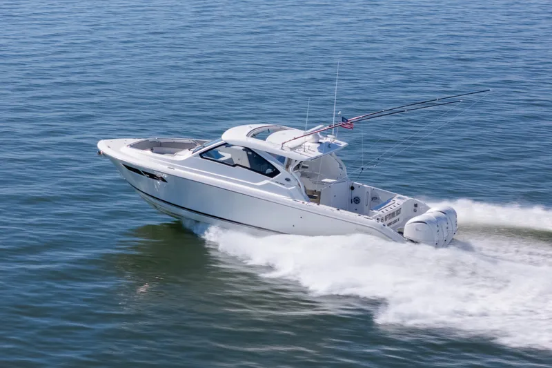Slide: The Image of 2021 Pursuit DC 365 Dual Console boat cruising on open water. - 4