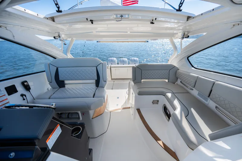 Slide: The Image of 2021 Pursuit DC 365 Dual Console boat interior with luxurious seating and ocean view. - 38