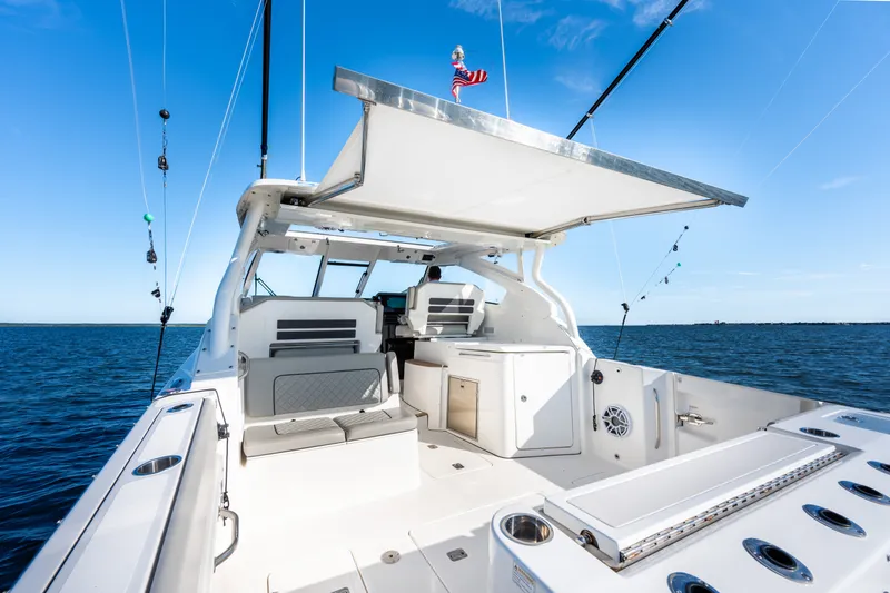 Slide: The Image of 2021 Pursuit DC 365 Dual Console boat on open water, featuring spacious seating and fishing equipment. - 30