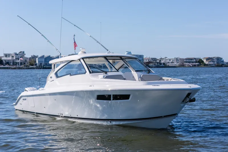 Slide: The Image of 2021 Pursuit DC 365 Dual Console boat cruising on a calm waterway. - 12