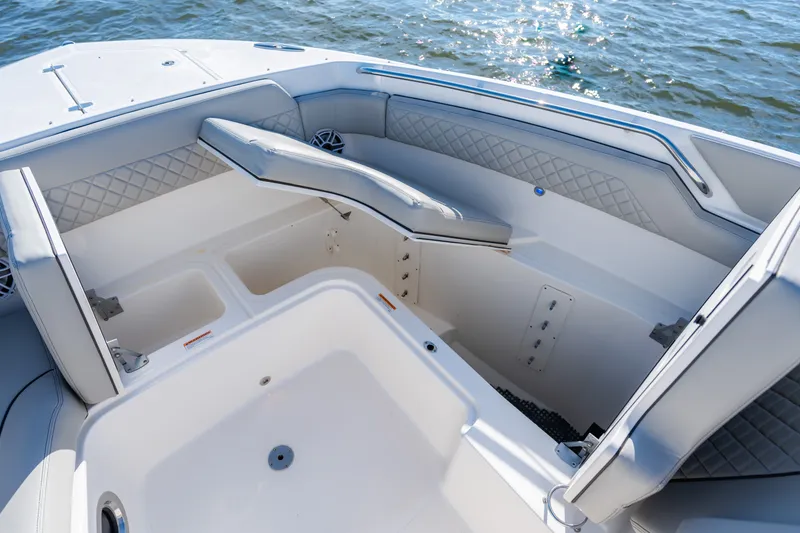 Slide: The Image of 2021 Pursuit DC 365 Dual Console boat interior with cushioned seating and storage compartments. - 42