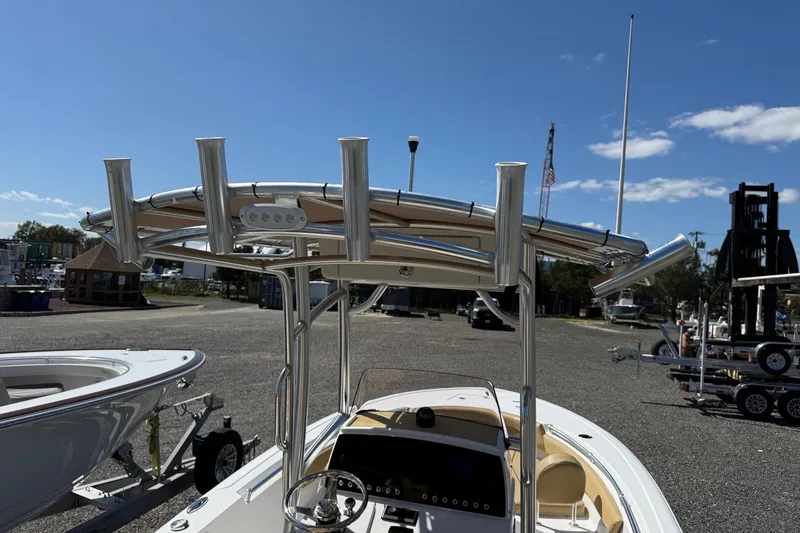 Slide: The Image of 2022 Sportsman Open 212 Center Console boat with T-top and rod holders in a marina. - 20