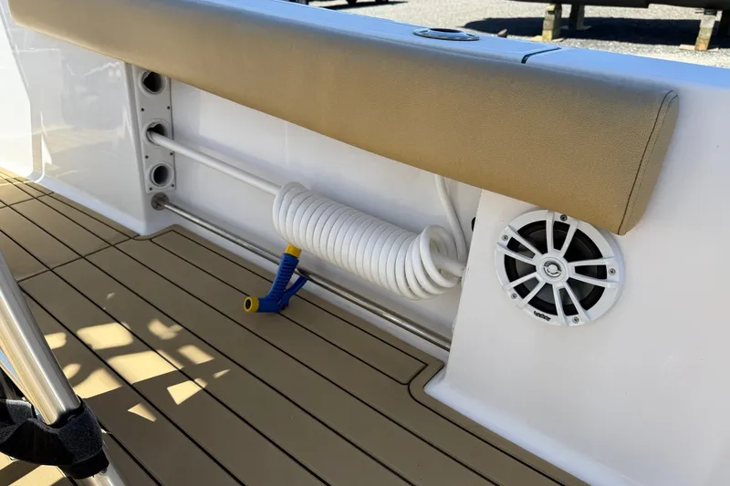 Slide: The Image of 2022 Sportsman Open 212 Center Console boat interior with coiled hose and speaker. - 19