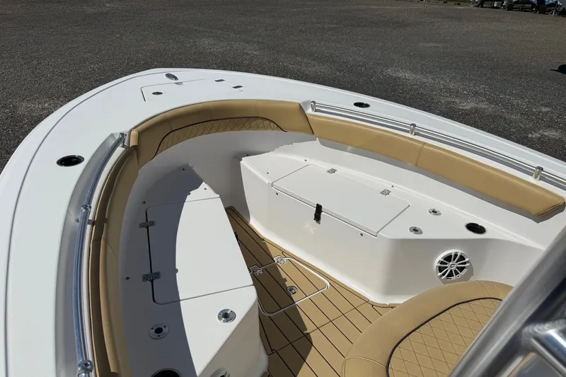 Slide: The Image of 2022 Sportsman Open 212 Center Console boat interior with tan seating and storage compartments. - 2
