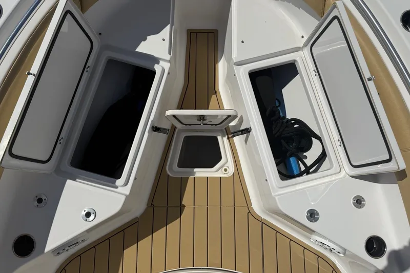 Slide: The Image of The image shows the bow of a Sportsman Open 212 Center Console boat with storage compartments. - 4