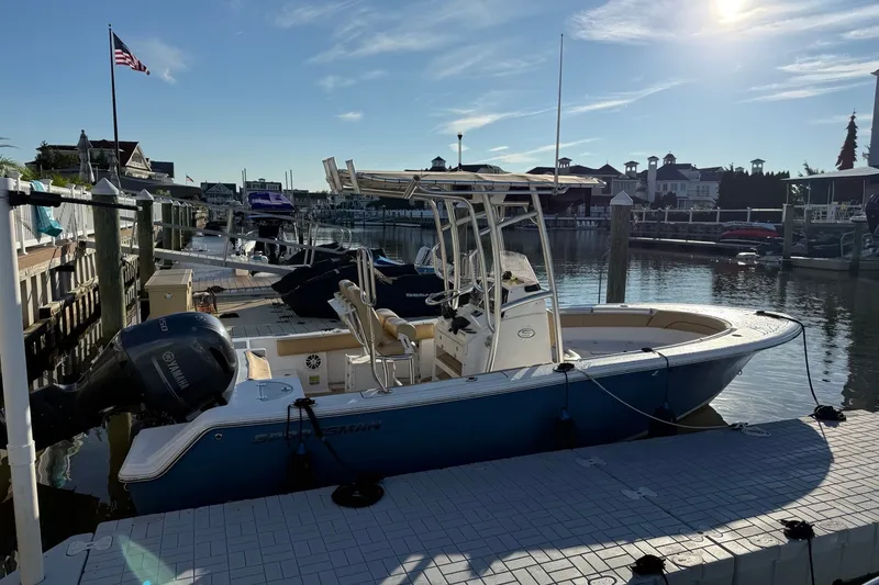 The Image of 2022 Sportsman Open 212 Center Console boat docked at a marina under a clear sky. - 0