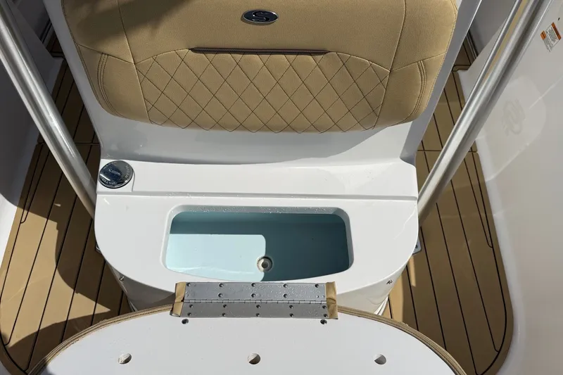Slide: The Image of 2022 Sportsman Open 212 Center Console boat interior with cushioned seating and storage compartment. - 7