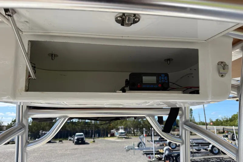 Slide: The Image of 2022 Sportsman Open 212 Center Console storage compartment with electronic equipment. - 14