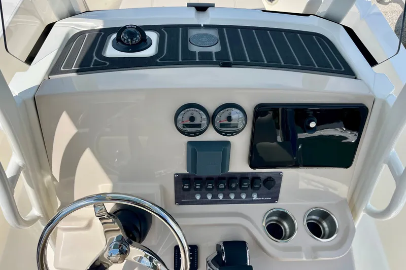 Slide: The Image of 2027 Boston Whaler 220 Dauntless dashboard with steering wheel, gauges, and controls. - 21