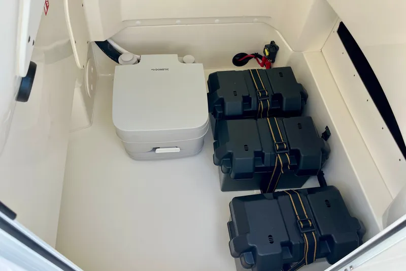 Slide: The Image of Interior storage of 2027 Boston Whaler 220 Dauntless with portable toilet and battery boxes. - 28