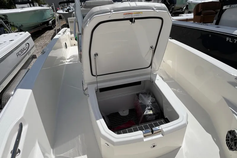 Slide: The Image of 2027 Boston Whaler 220 Dauntless boat with open storage compartment on deck. - 27