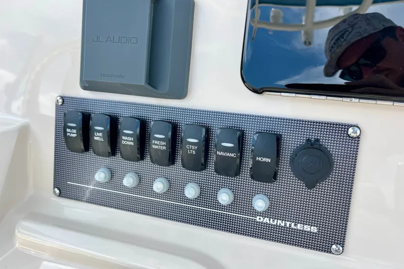 Slide: The Image of Control panel of 2027 Boston Whaler 220 Dauntless boat with various switches. - 18
